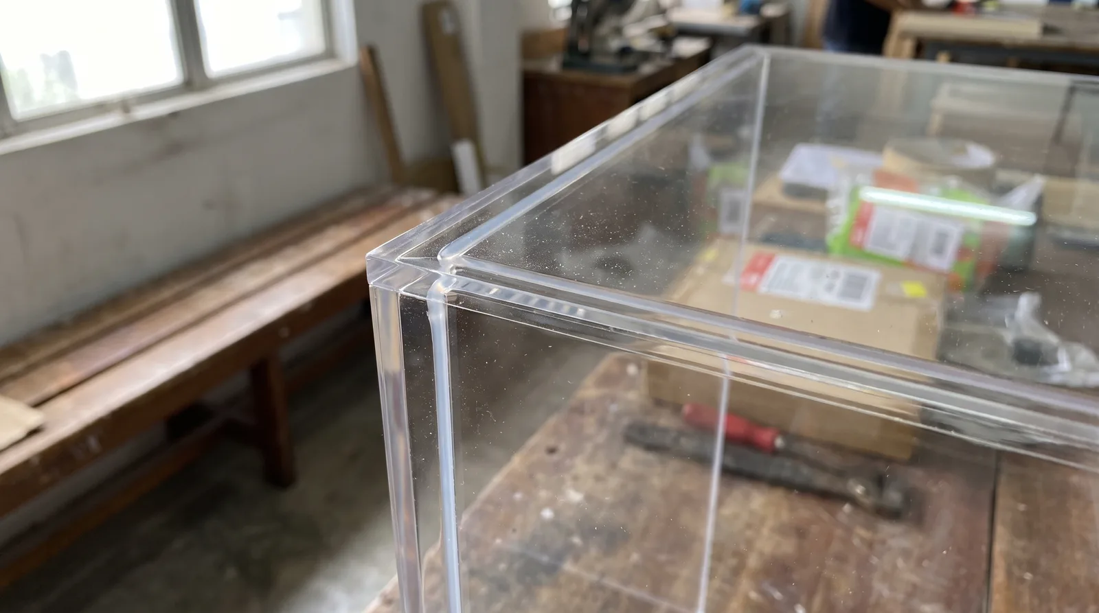 close-up of an acrylic display case corner joint, showing the clean polished edge and dust seal
