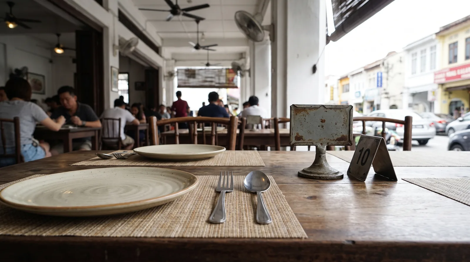 restaurant table set for service with a small standing table marker beside the cutlery