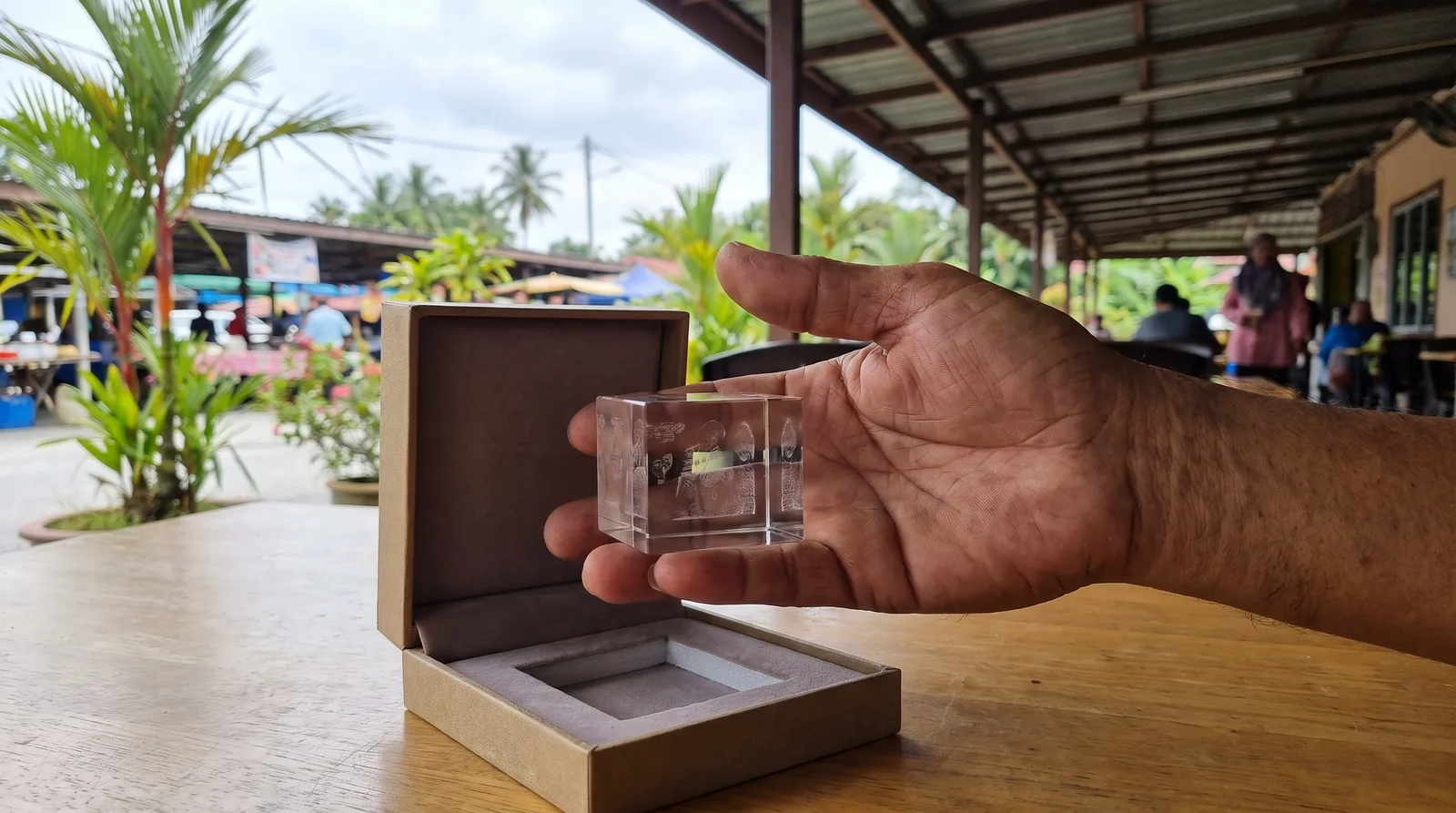 hand presenting a small engraved acrylic keepsake in an open gift box