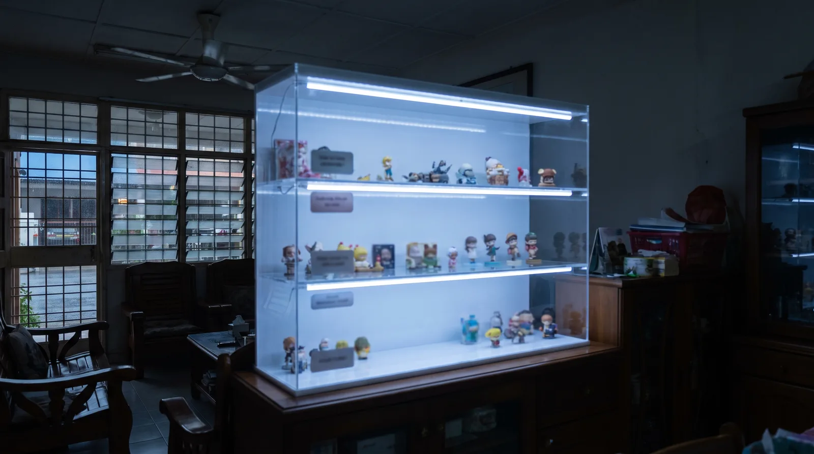 LED-lit acrylic display case glowing in a dim room, light washing evenly across the shelves