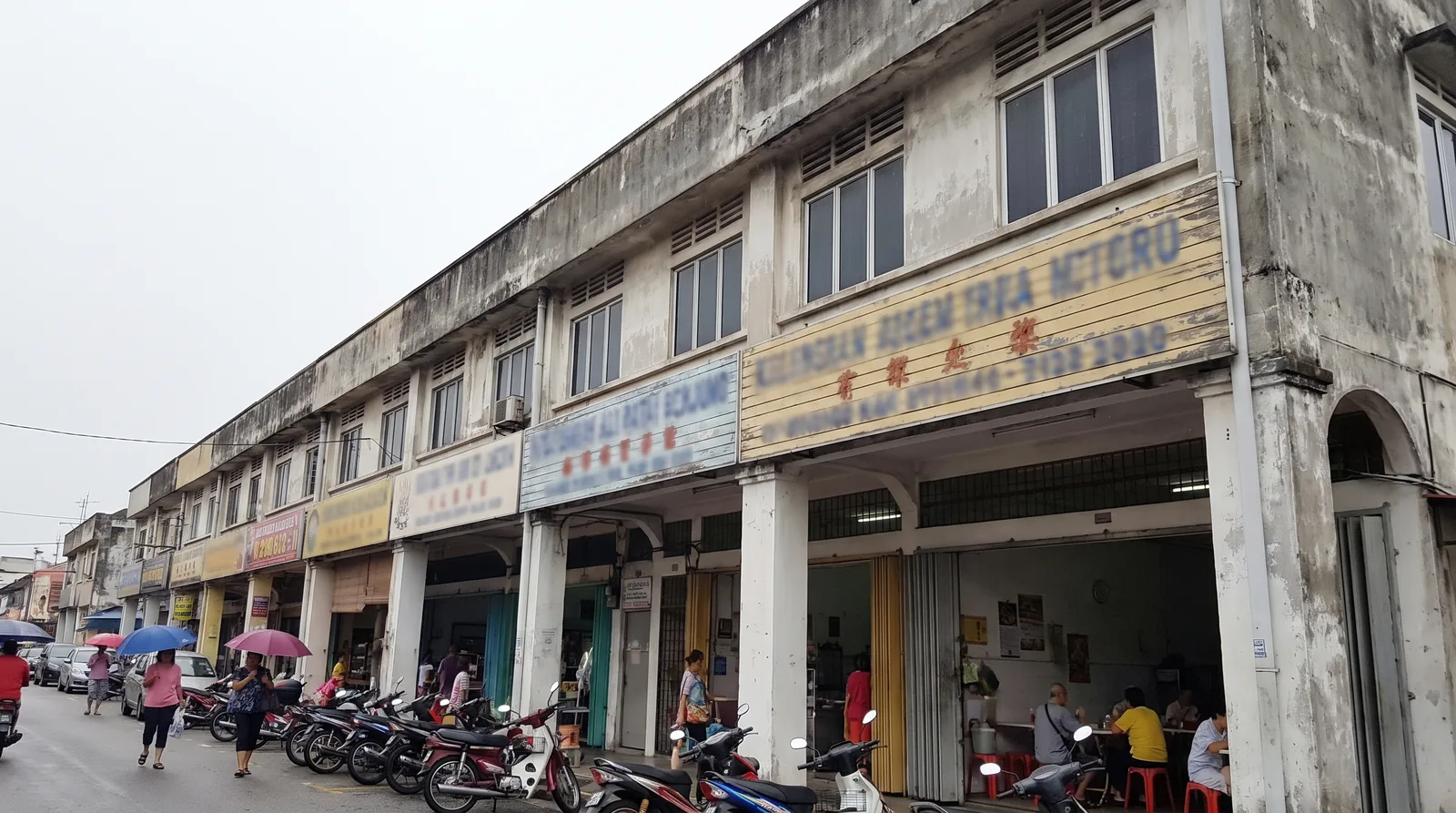 row of Malaysian shoplots with compliant horizontal fascia signboards above the covered walkway