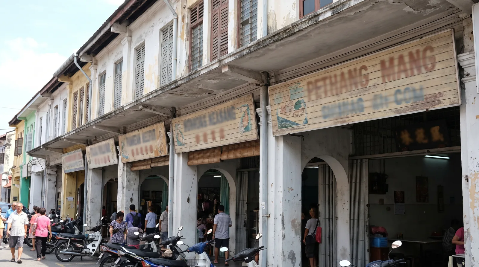 row of Malaysian shoplots with compliant horizontal fascia signboards above the covered walkway