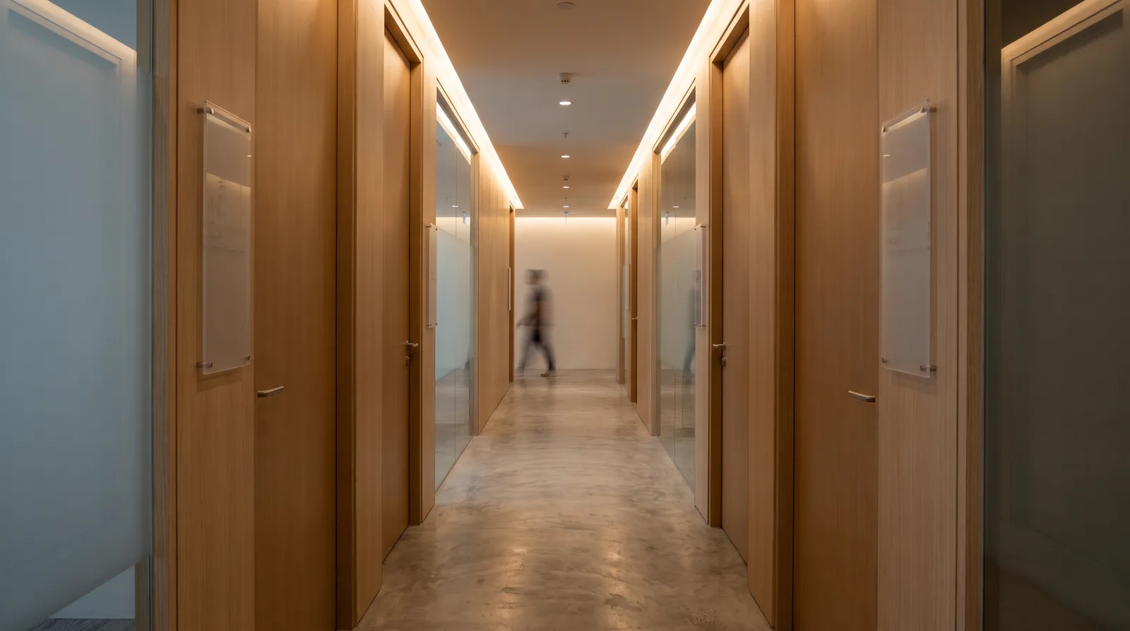 modern Malaysian office corridor with slim acrylic name plates mounted beside each closed door, soft ceiling lighting
