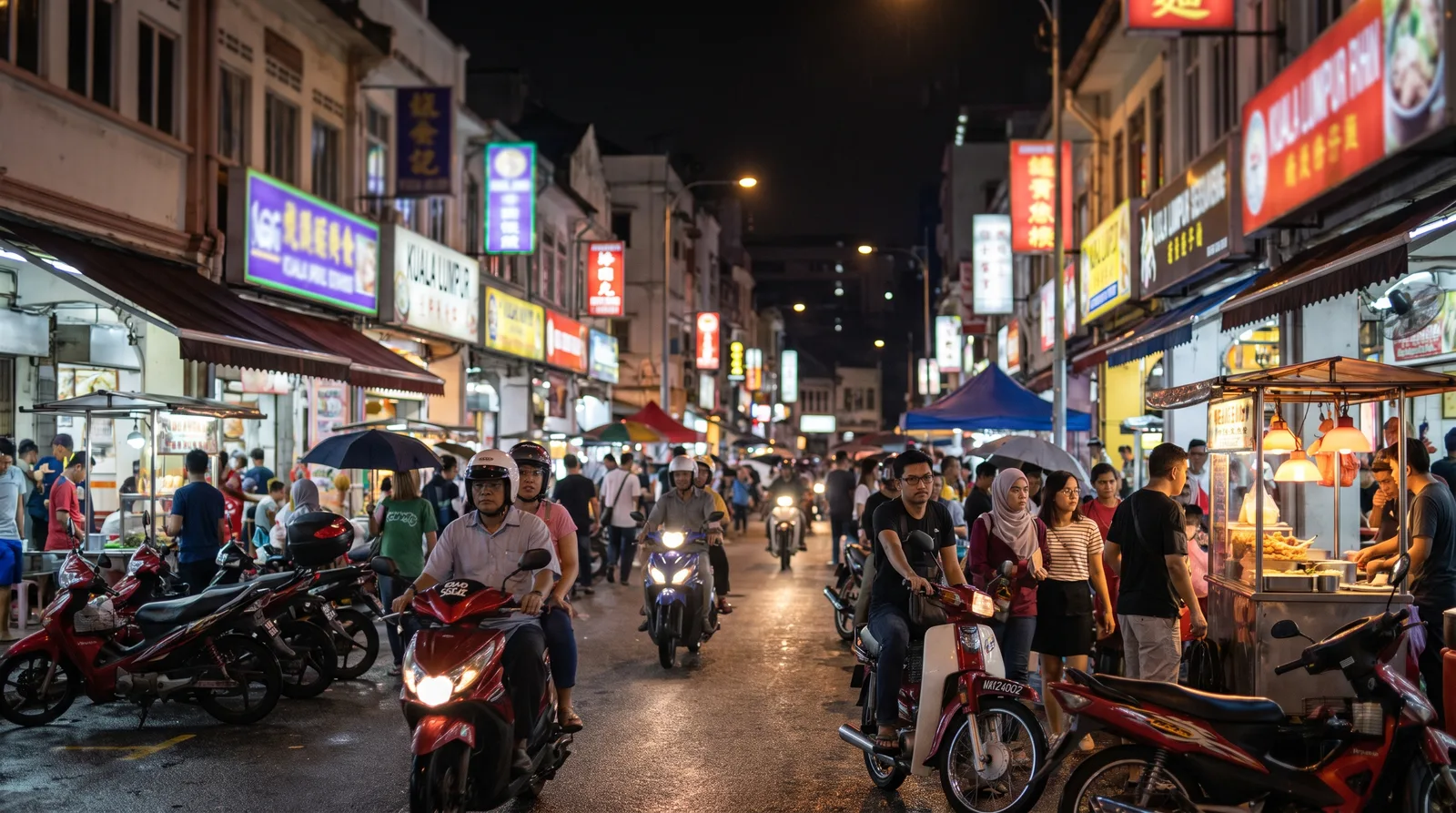 busy Malaysian commercial street at night, shopfront signs glowing along both sides of the road