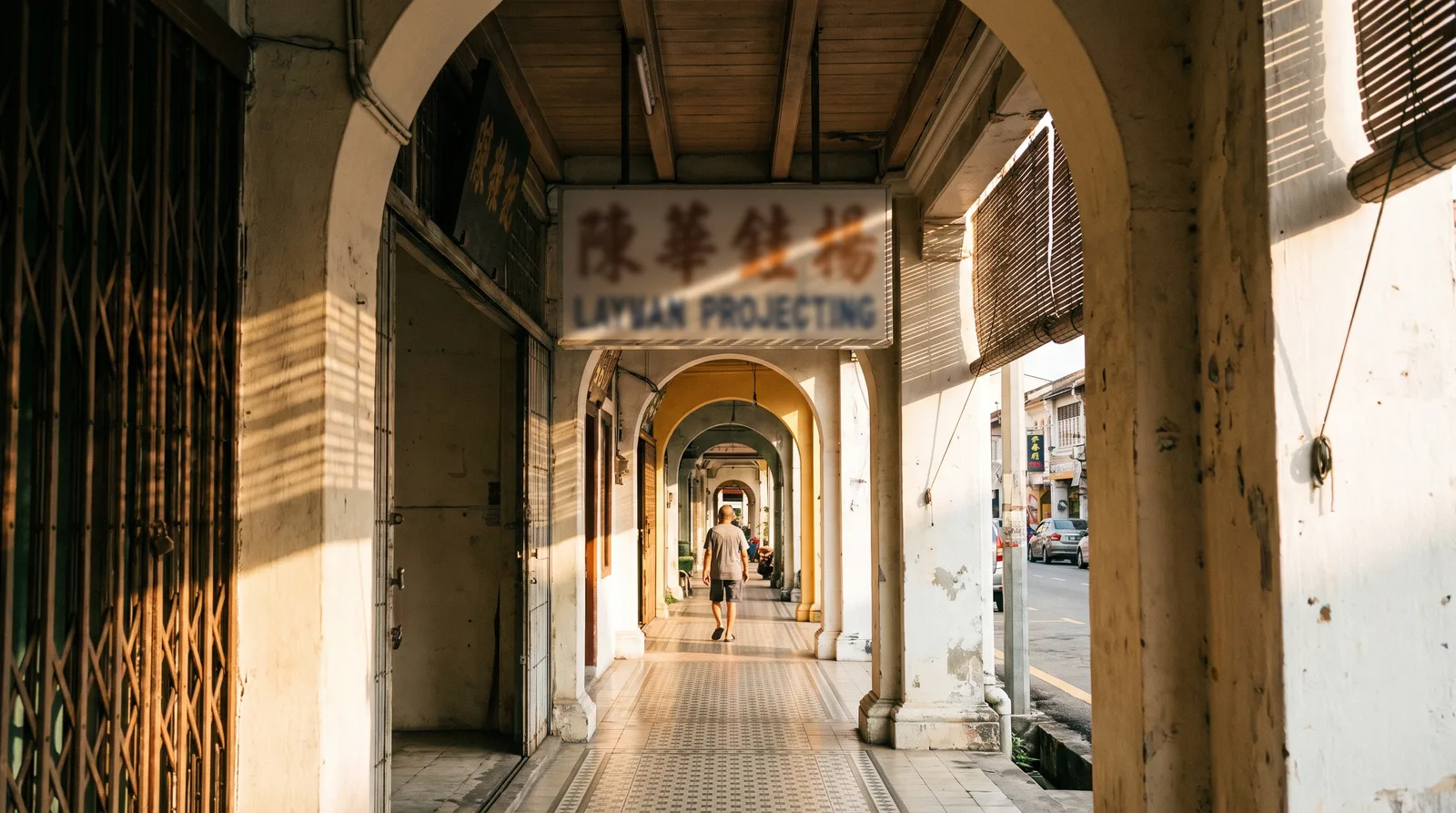 Double-sided projecting signboard mounted above a five-foot way walkway with ground clearance