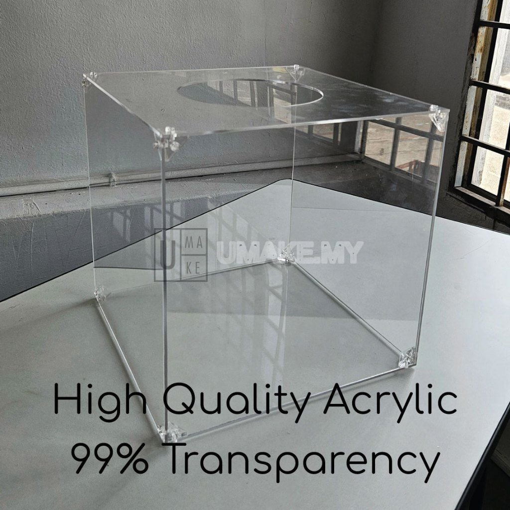 Clear acrylic cube lucky draw box photographed on a table to show its transparency